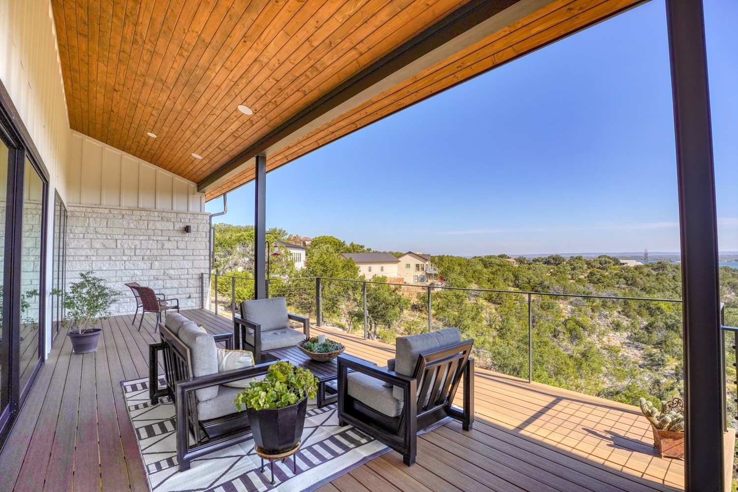 Hill Country Contemporary — metal roof, limestone, and cable railing deck with Hill Country backdrop — Grubbs Construction