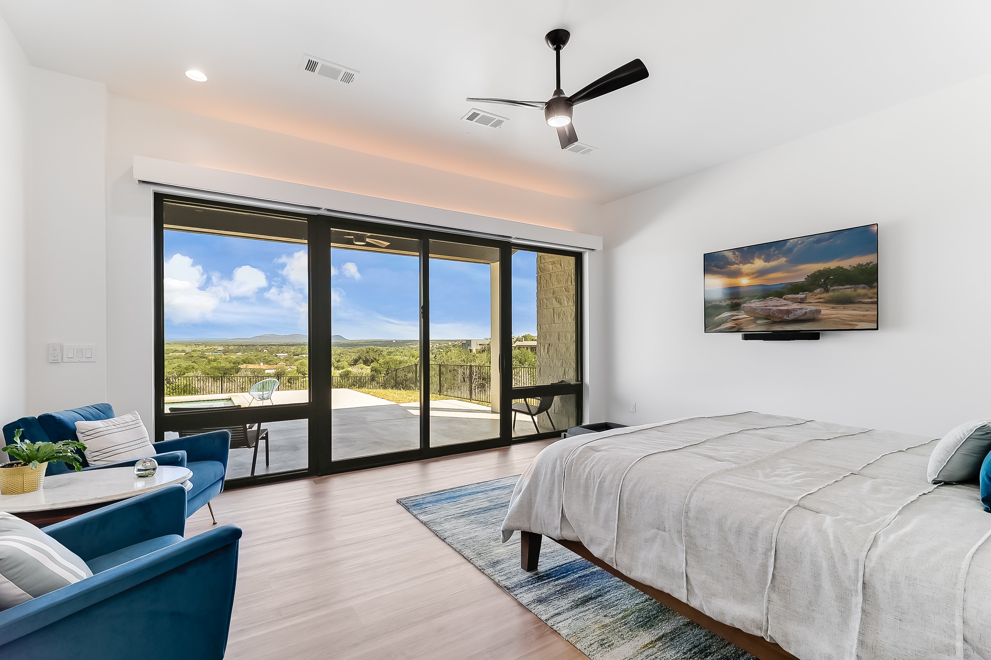 Primary suite with panoramic Hill Country views through floor-to-ceiling sliding doors, The Architect's View